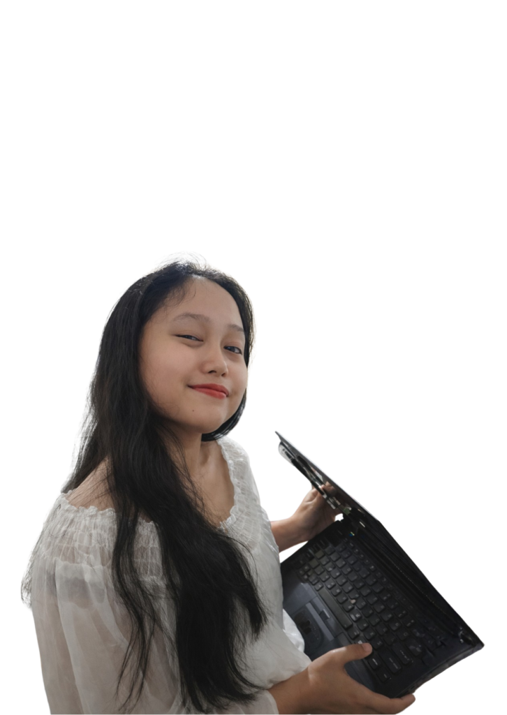 Zelly Looking at Camera while holding a laptop